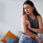 femme qui se gratte le bras